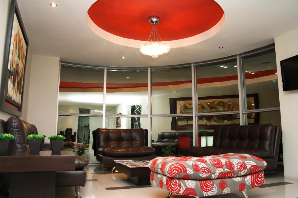 sala de estar con muebles de cuero y techo rojo en Intiotel Piura, en Piura