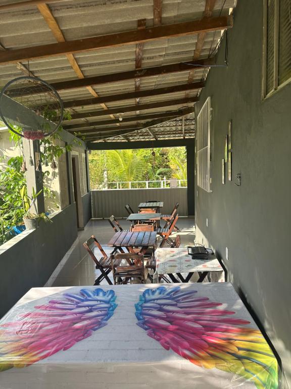a patio with a table with colorful wings on it at Pousada Hostels Foryou in Ibiraçu