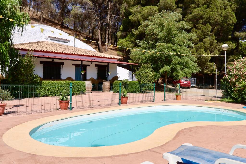 a large swimming pool in front of a house at CASA CUEVA PIENA, Alcudia de Guadix in Alcudia de Guadix