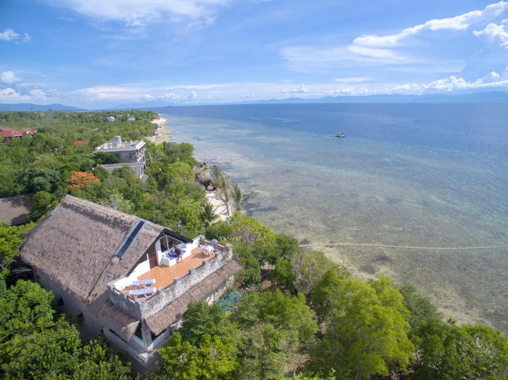 an aerial view of a house and the ocean at The Blue Orchid Resort in Moalboal