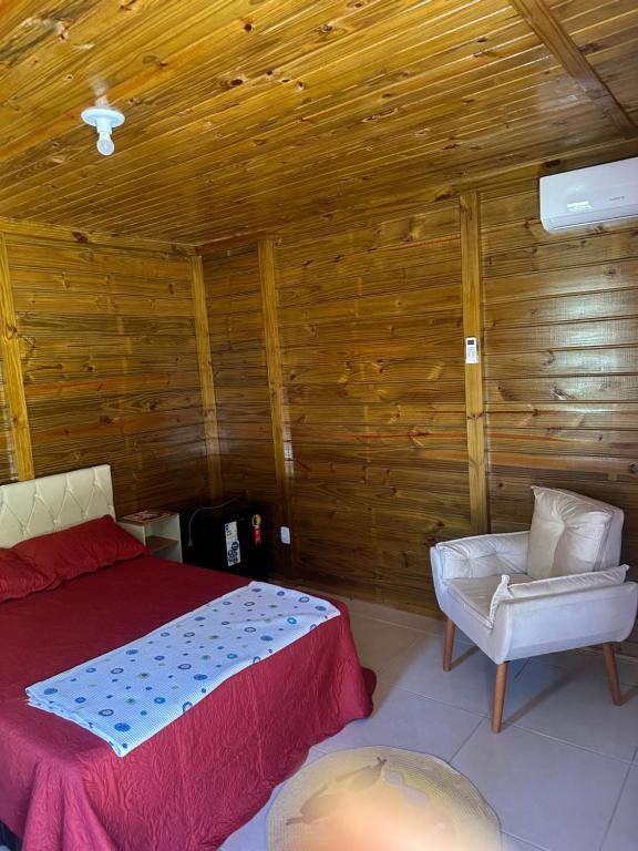 a bedroom with a bed and a chair in a room at Pousada Hostels Foryou in Ibiraçu