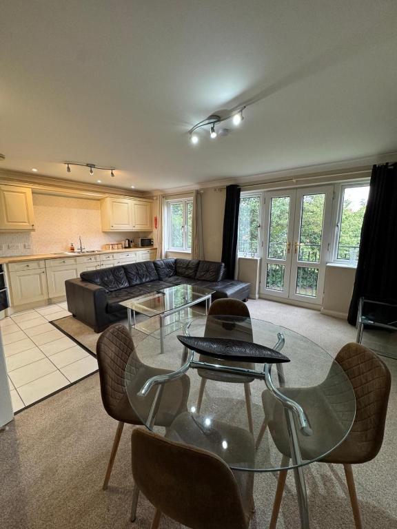 a living room with a glass table and chairs at Spacious Two Bedroom Apartment in Bracknell in Bracknell