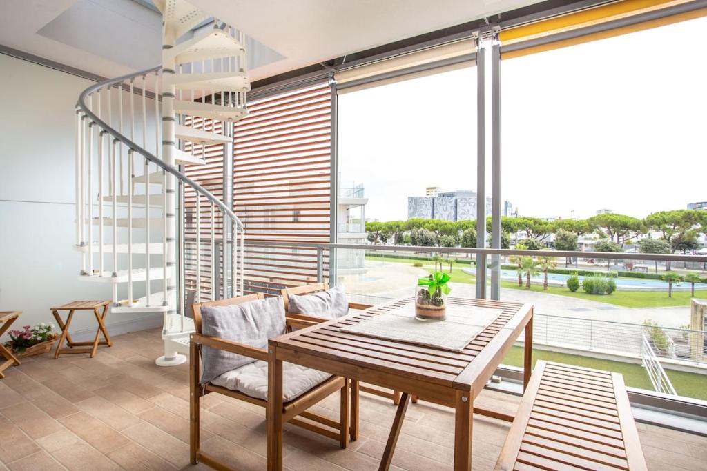 ein Esszimmer mit Tisch und Stühlen und einem großen Fenster in der Unterkunft Jesolo Vista Lido - Rooftop Suite in Lido di Jesolo