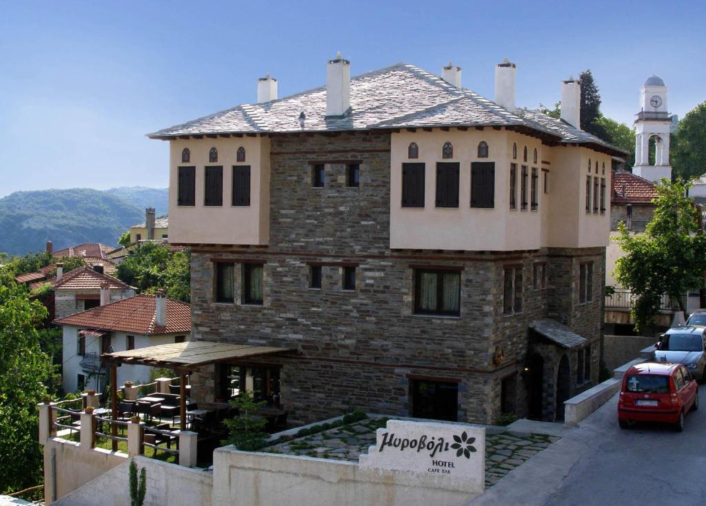 a large brick building with a sign in front of it at Hotel Mirovoli in Miléai