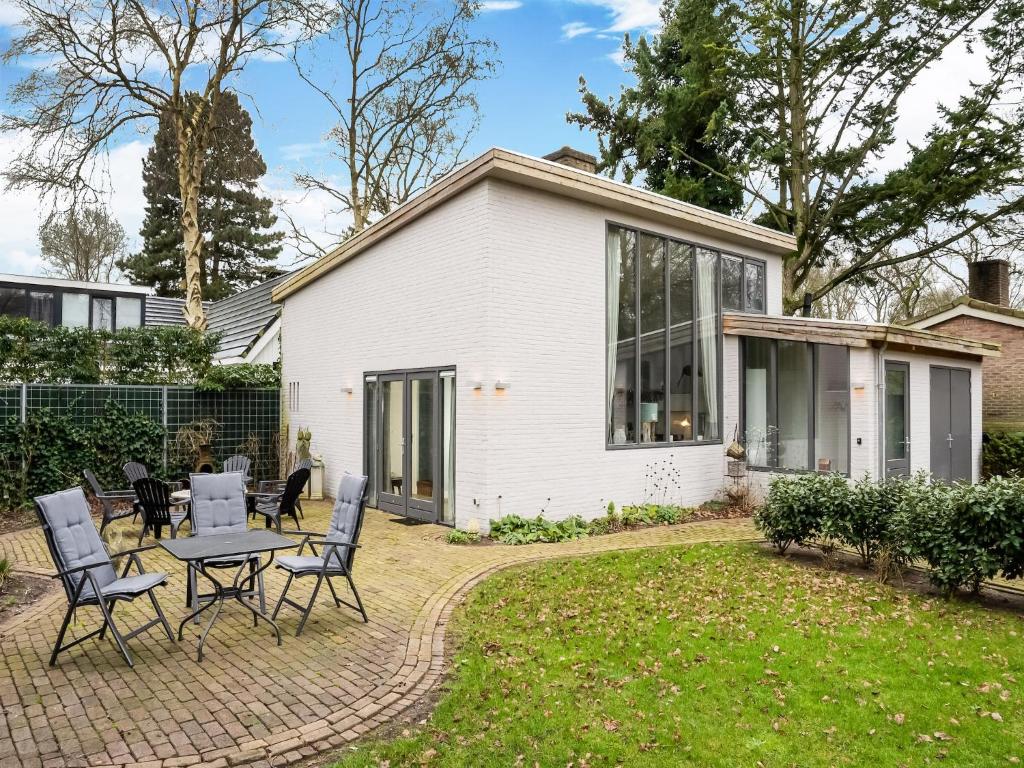 a white house with a table and chairs in the yard at Modern Forest Retreat in Bergen in Bergen