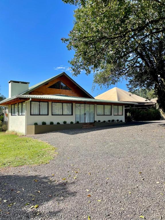a house with a driveway in front of it at Rancho Áustria - Hospedagem Exclusiva in Treze Tílias