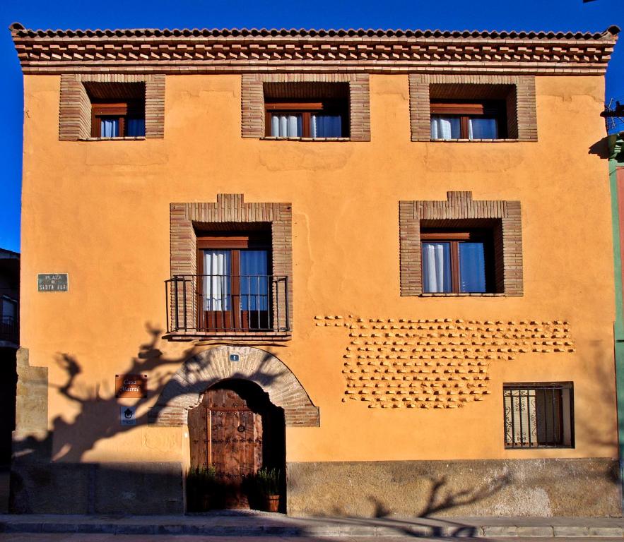 ein orangefarbenes Backsteingebäude mit Fenstern und einer Tür in der Unterkunft Casa Mairal in Salillas