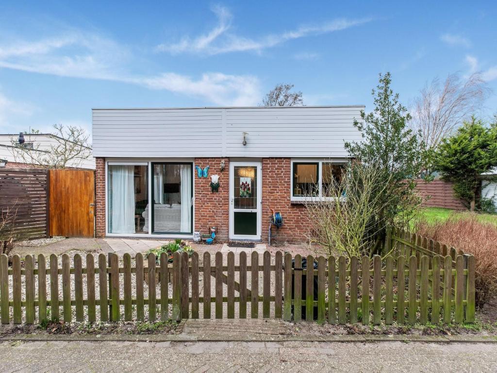 une maison en briques avec une clôture devant elle dans l'établissement Holiday Home in Noordwijkerhout near Lake, à Noordwijkerhout