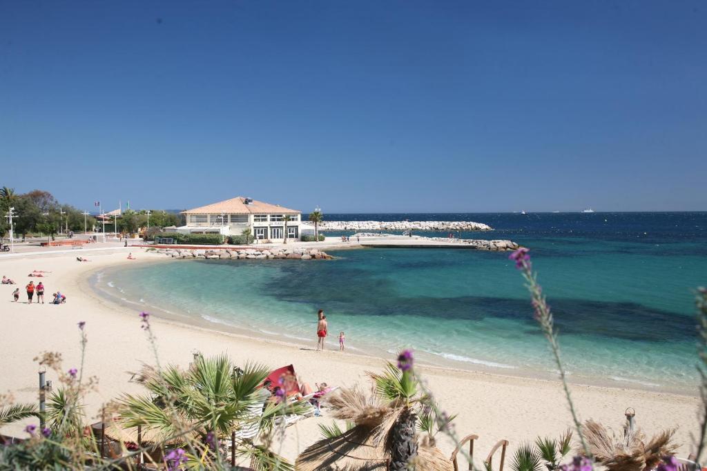 une vue d'une plage avec des gens dans l'eau dans l'établissement Résidence les Ibis Location entre mer et montagne, à Toulon