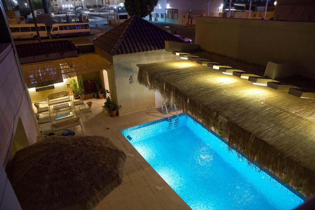 an overhead view of a swimming pool at night at Tayba Alkubra Hostel, Place of your comfort in Riyadh