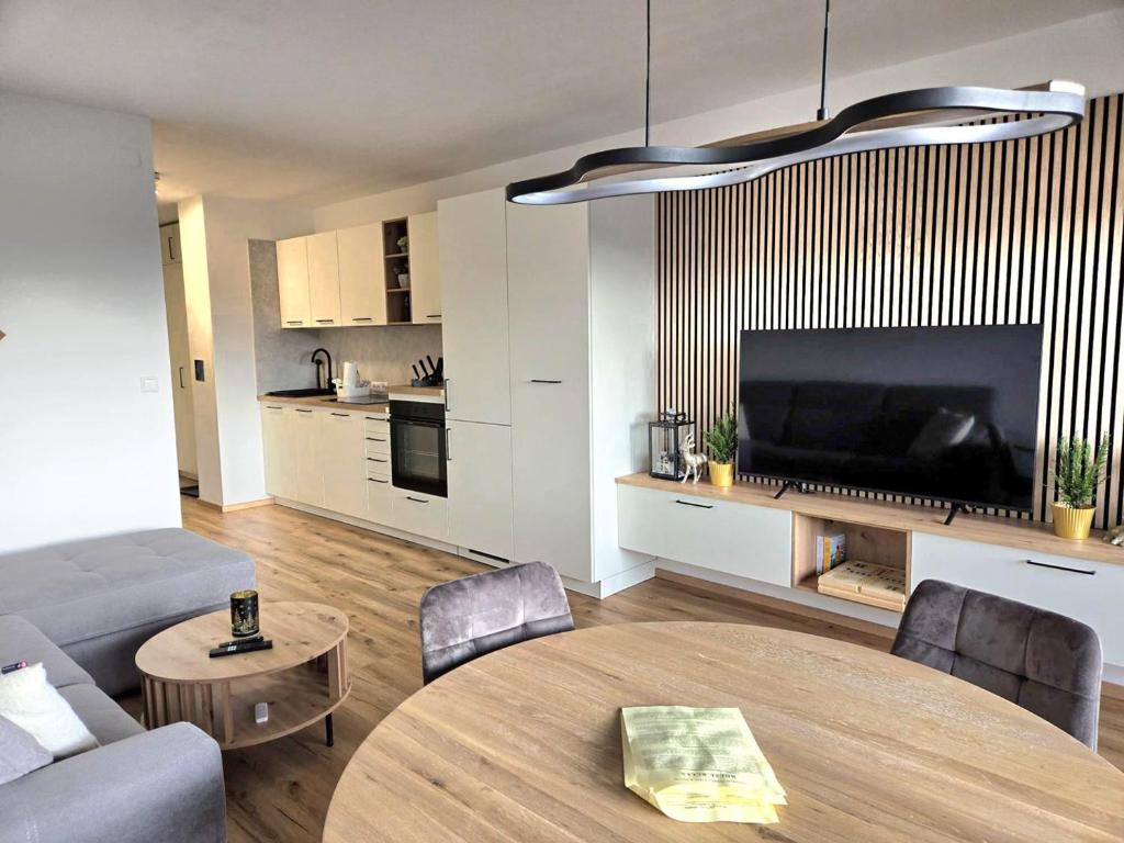 a living room with a couch and a table and a television at Bergapartment Simonhöhe in Zirkitz