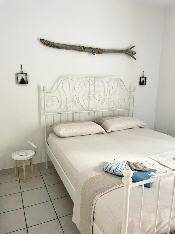 a bedroom with a white bed and a branch on the wall at Condominio Tirrenia 5 in Lignano Sabbiadoro