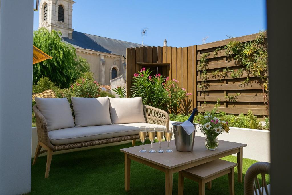 a patio with a couch and a table at Superbe maison de centre ville avec garage 2places - 6 personnes in Les Sables-dʼOlonne