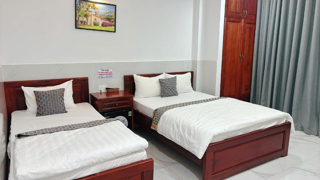 two beds in a small room withermottermott at Phòng cho thuê 216 Ga Sài Gòn in Ho Chi Minh City