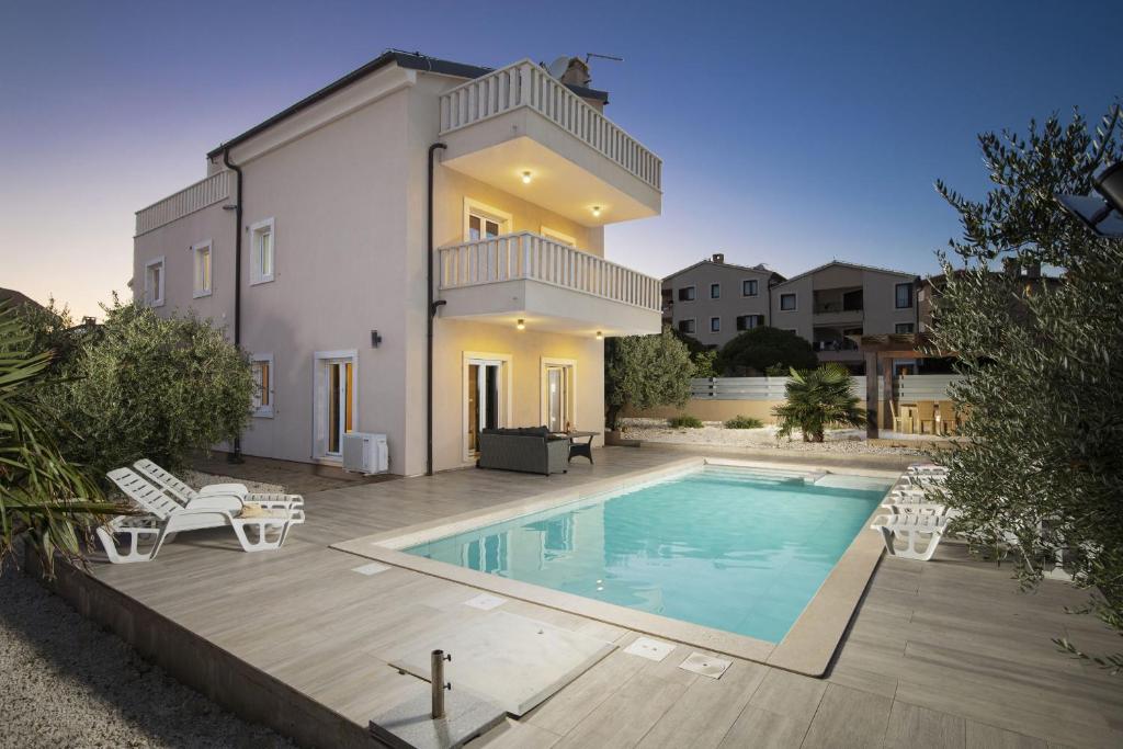 a villa with a swimming pool and a house at Villa Bellavista with 8 Bedrooms, Private Pool and Sauna in Premantura