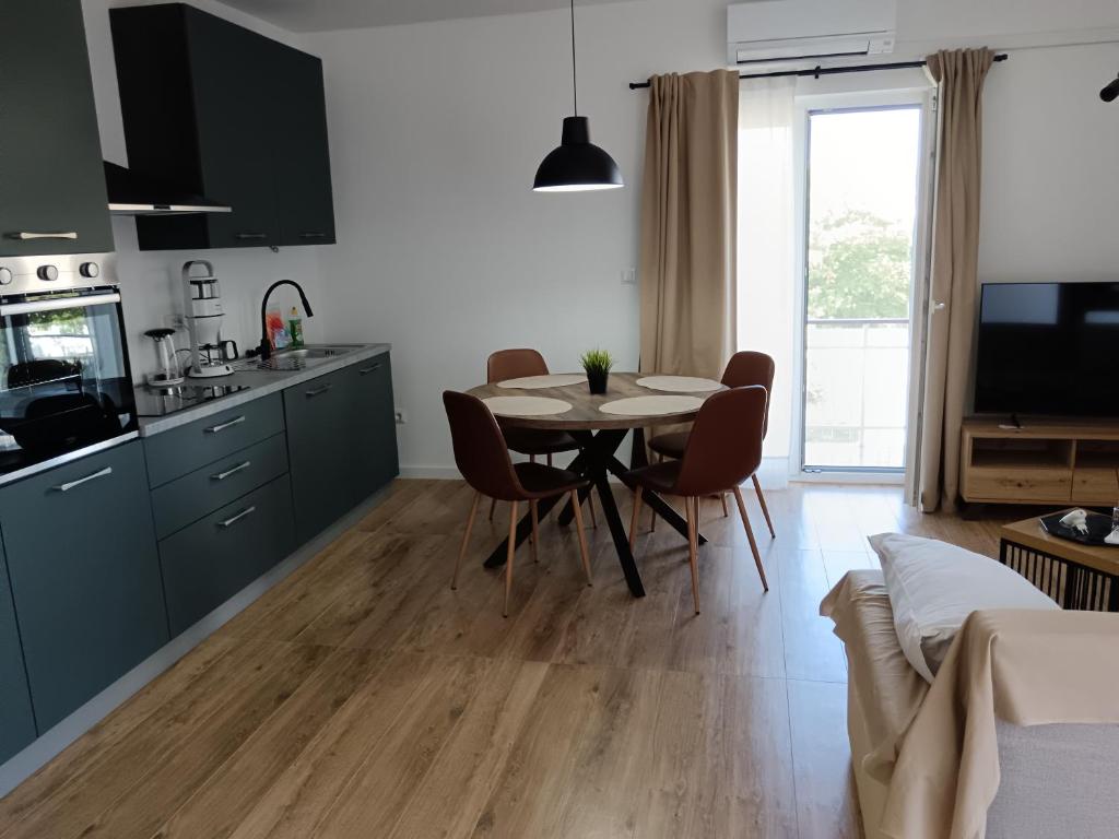 a kitchen and dining room with a table and chairs at Apartman PAVLA in Betina