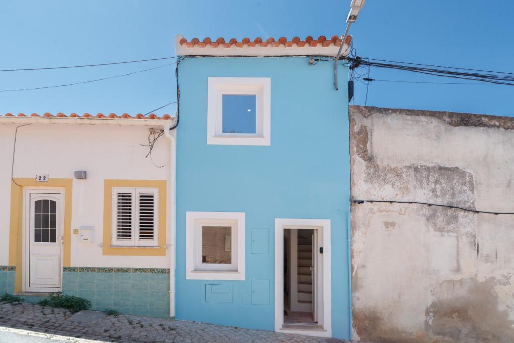 a blue house with two windows in a street at Alma Marina Lagos in Lagos