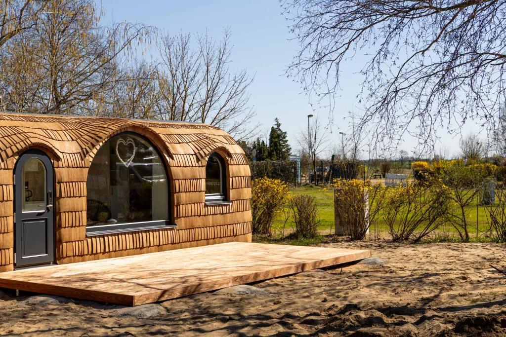 a small wooden shed with a wooden deck at Iglus 4 Personen - Jersleber See Camping & Erlebnisresort in Jersleben