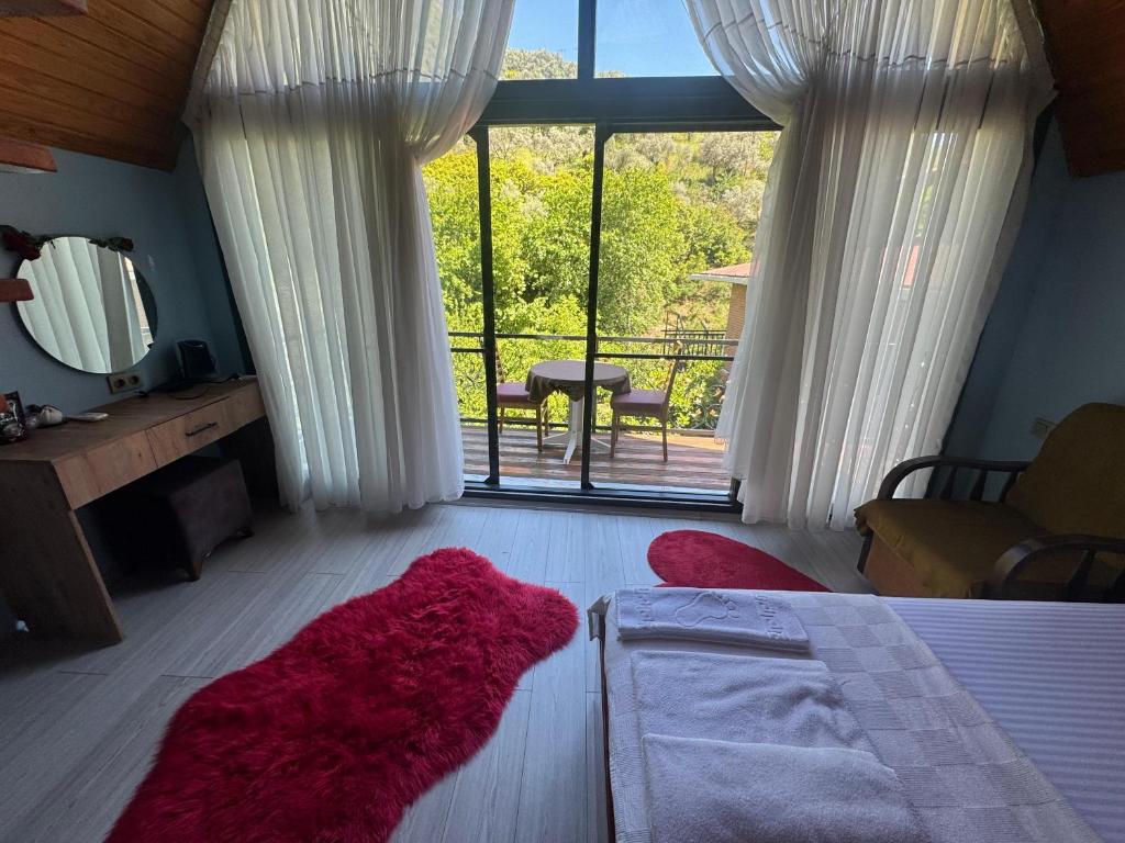 ein Schlafzimmer mit einem Bett und einem großen Fenster in der Unterkunft Ahsen pansiyon in Selçuk