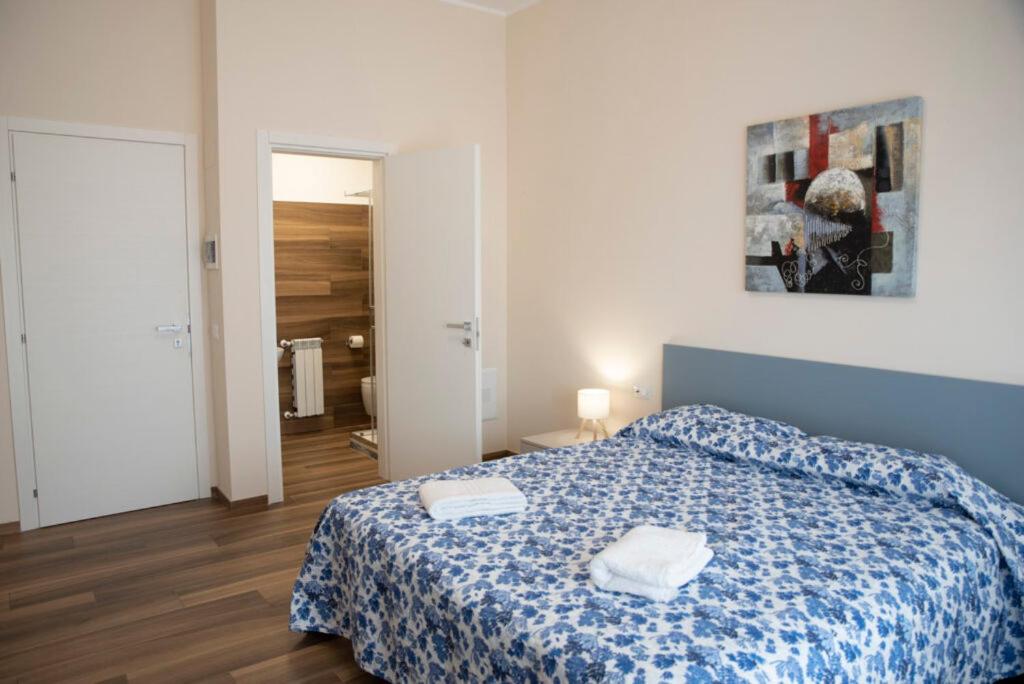 Un dormitorio con una cama azul con dos toallas encima. en Akrone Rooms City Center, en Agrigento