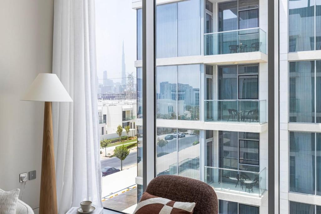 a room with a chair and a large window at District One Dubai Lagoon View Near Downtown in Dubai