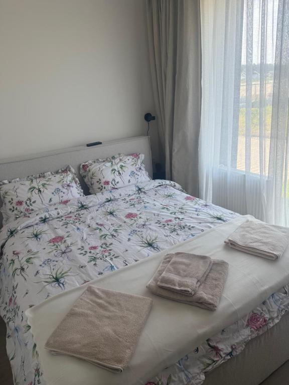 a bedroom with a bed with towels on it at Mano Jūra - apartamentų nuoma Mano Jūra 3 kvartale in Palanga