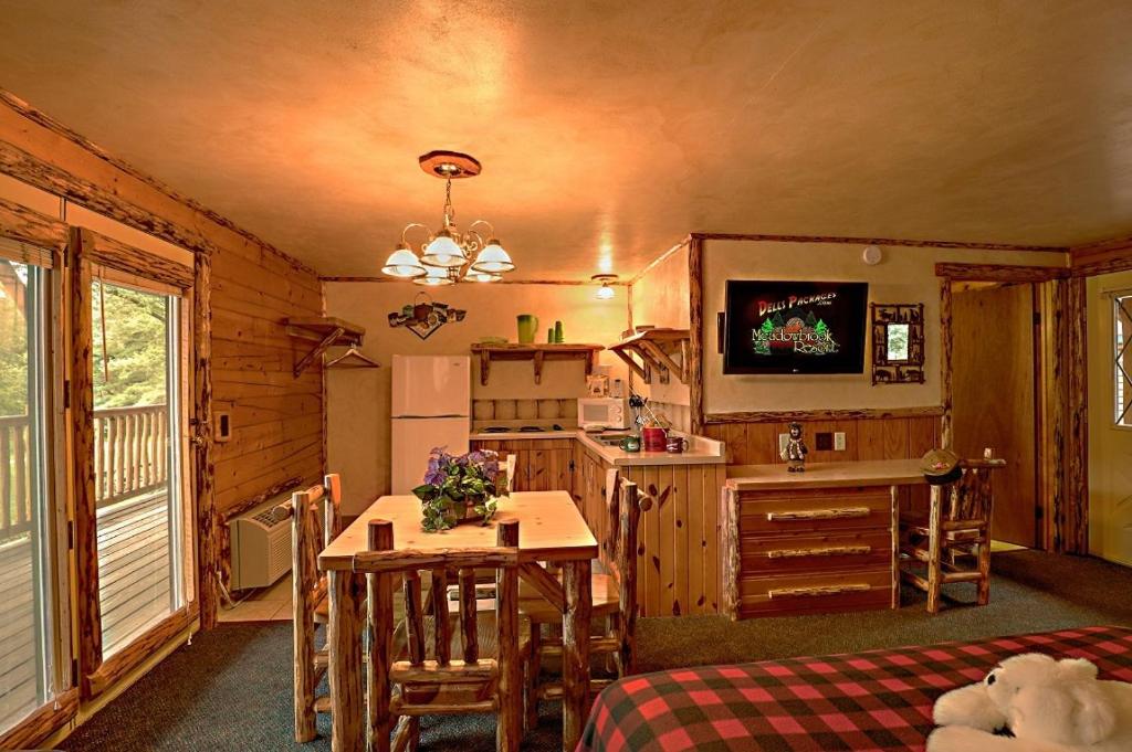 a room with a kitchen and a table in a cabin at Meadowbrook Resort in Wisconsin Dells