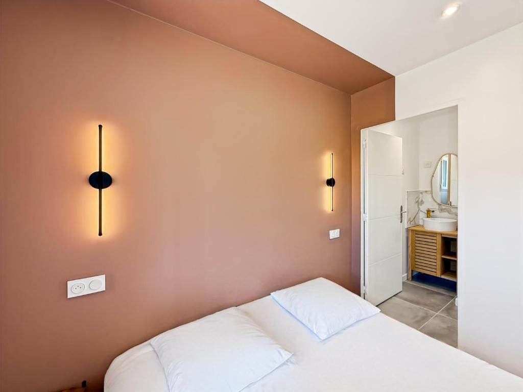 a bedroom with a white bed and a mirror at La Maisonnette - Jardin & Calme in Saint-Ouen-des-Alleux