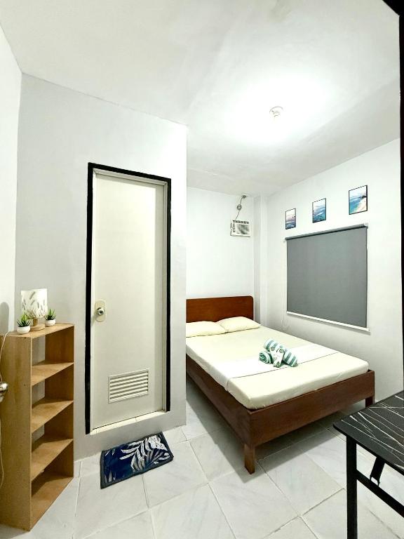a bedroom with a bed and a mirror at Wakim’s INN in Coron