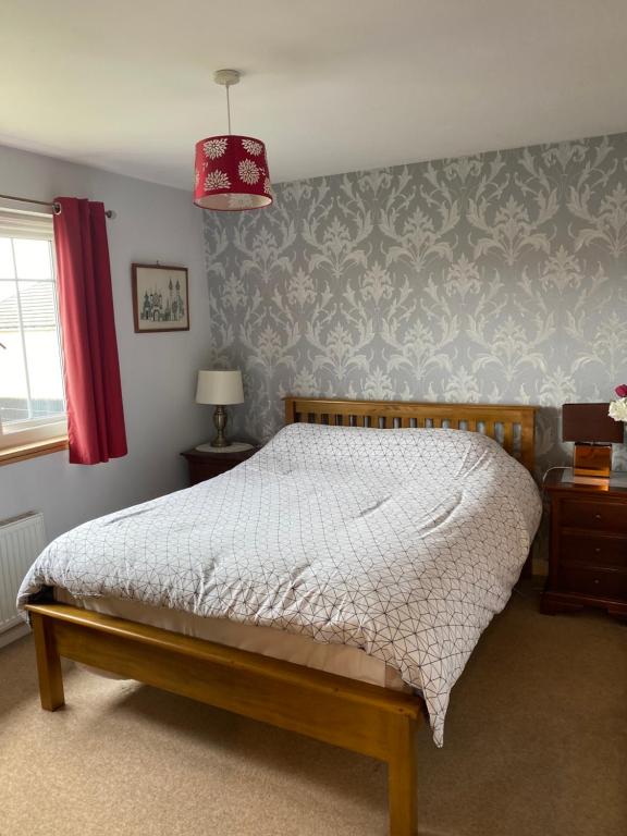 a bedroom with a bed and a red lamp at Caledonia House in Rosyth