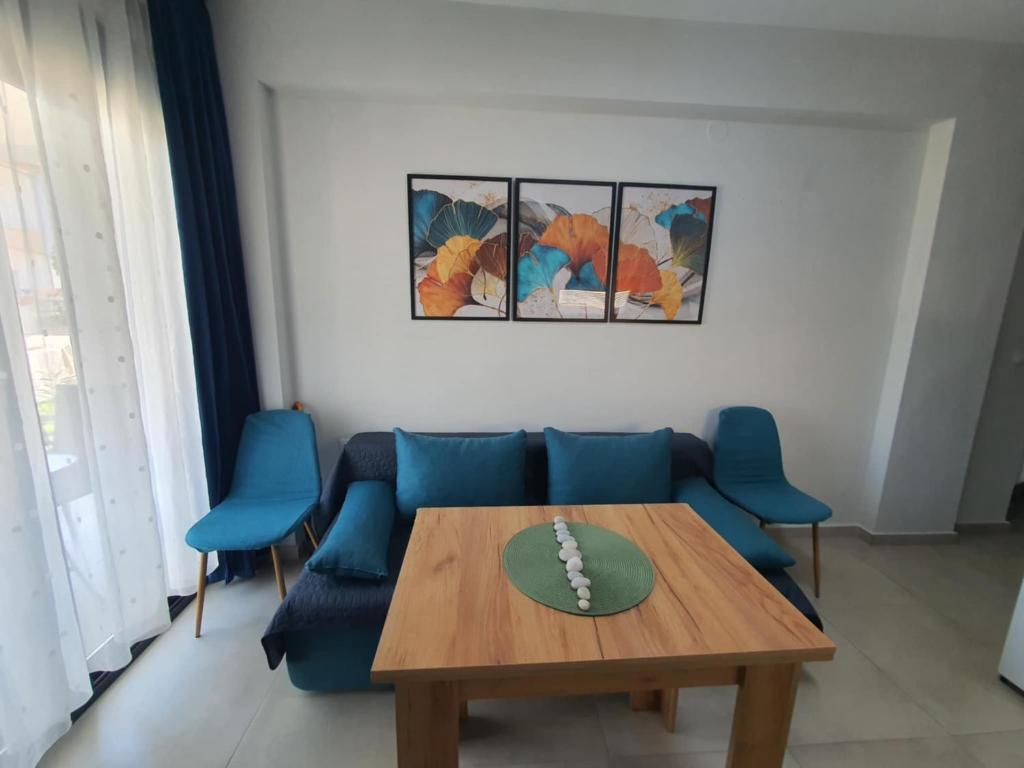 een woonkamer met een tafel en blauwe stoelen bij Sunny Apartment in Ofrínion
