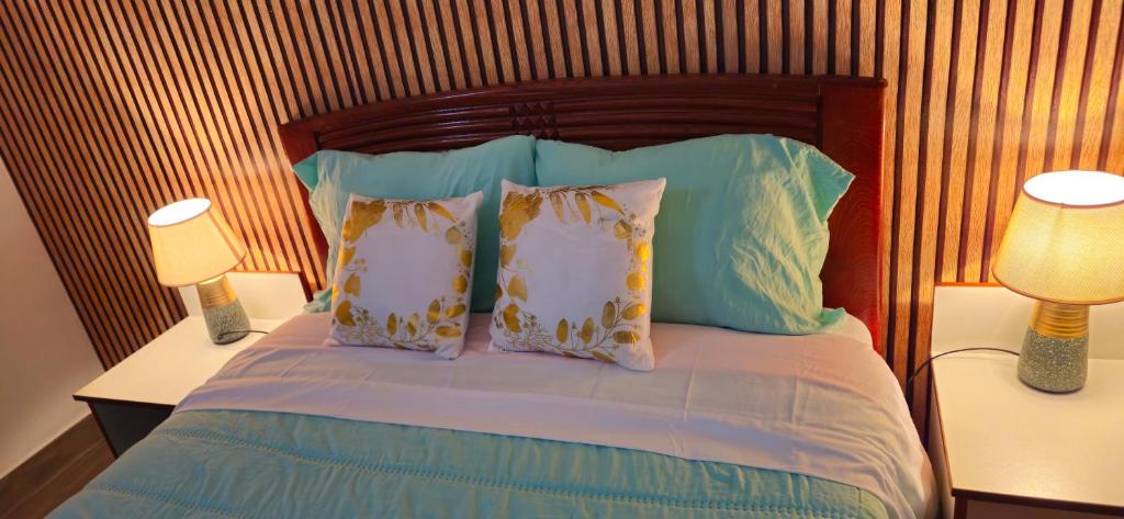 a bedroom with a bed with pillows and two lamps at Departamento mirador a 3minutos del centro de la ciudad in Chachapoyas
