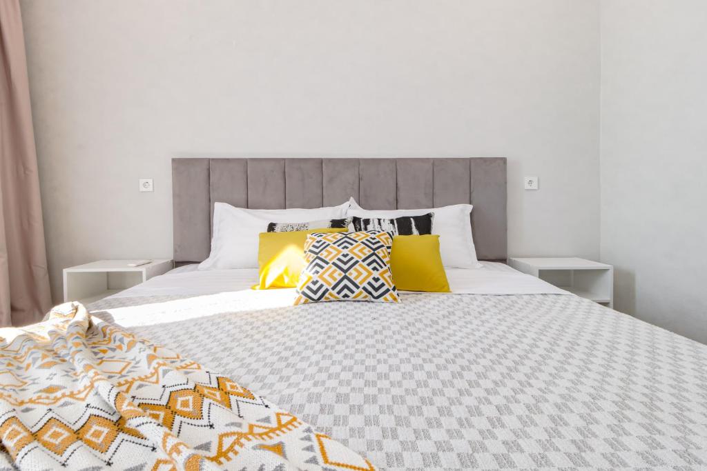 a bedroom with a large bed with yellow pillows at Aruna Deluxe Apartment идеально для туриста in Astana