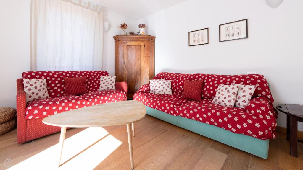 un soggiorno con un divano rosso e un tavolo di Italianway - Milano 35 a Bormio