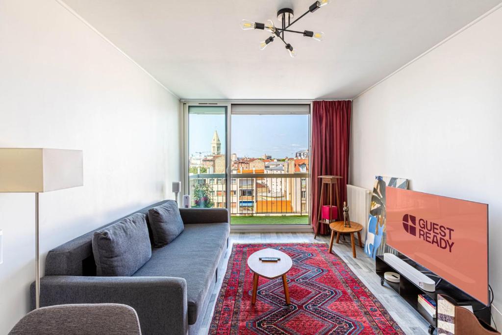 a living room with a couch and a large window at GuestReady - Excelente Aptos perto de Antique District in Saint-Ouen