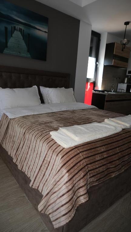 Una cama grande con una manta encima. en Mamaia-Summerland Beachfront Apartment, en Mamaia