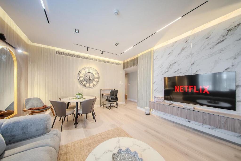 a living room with a tv on a wall at 2BR Private Apartment in Al Zahia, Sharjah - Stone Haven in Sharjah