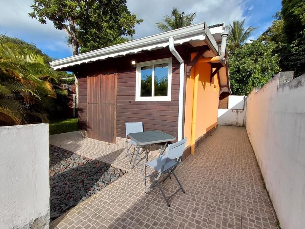 a table and chairs in front of a tiny house at Bungalow Dumonter in Baie-Mahault