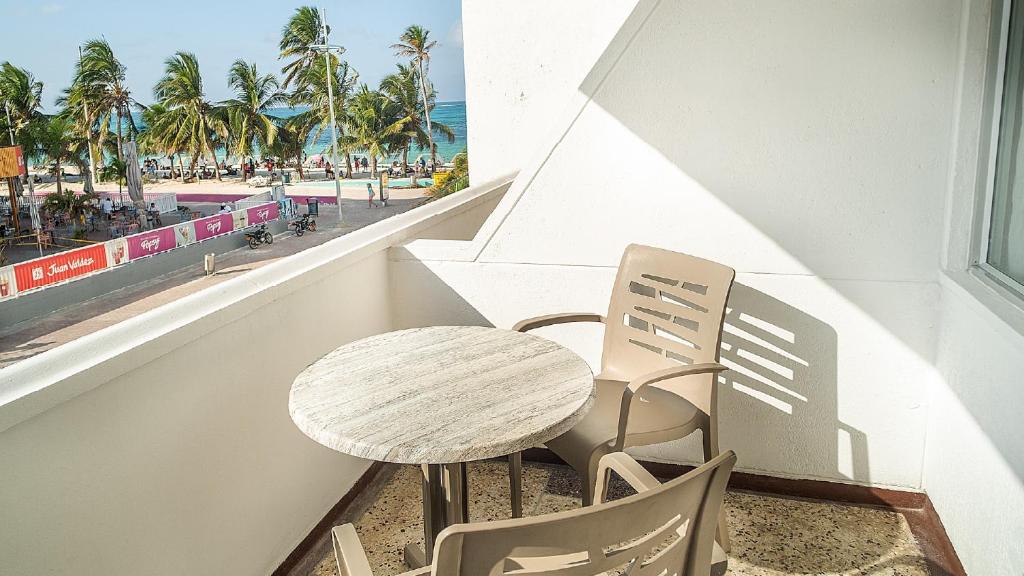 a table and chairs on a balcony with a view of the beach at Hotel Portobelo Convention Center in San Andrés