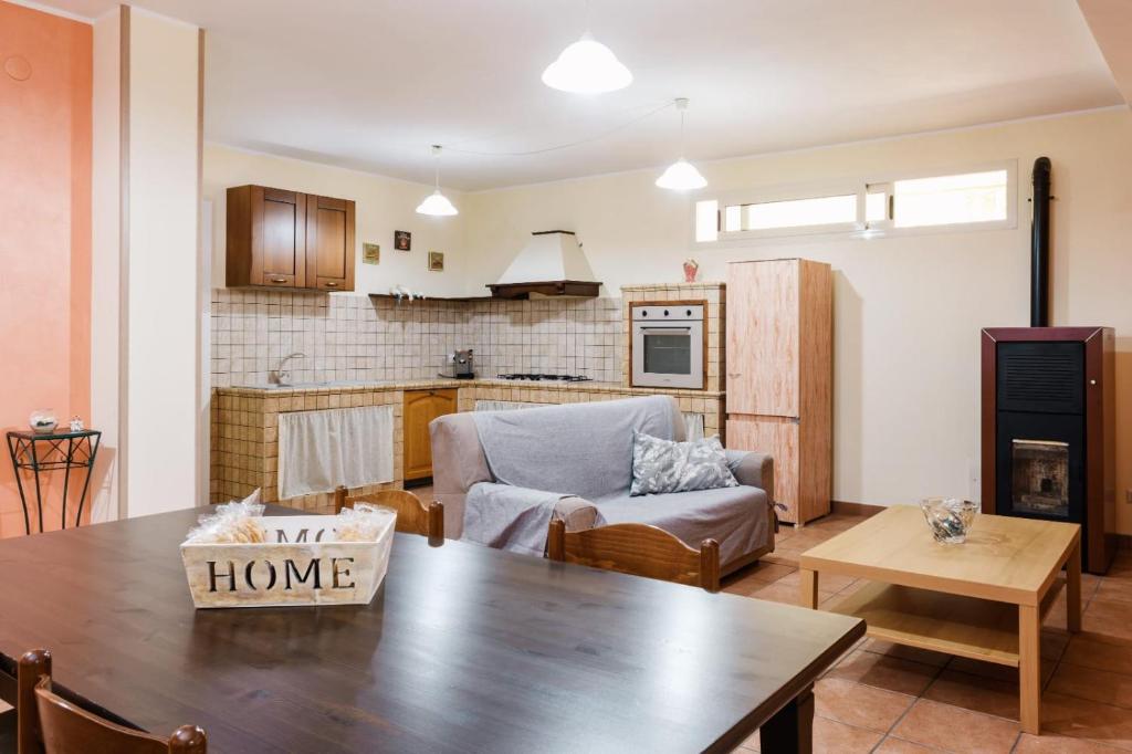 a living room with a table and a kitchen at Dormi'Re in Caserta