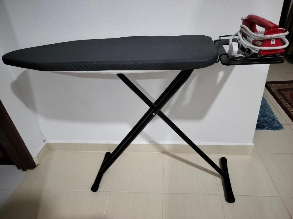a black ironing board sitting next to a wall at Liza Homestay in Bachok