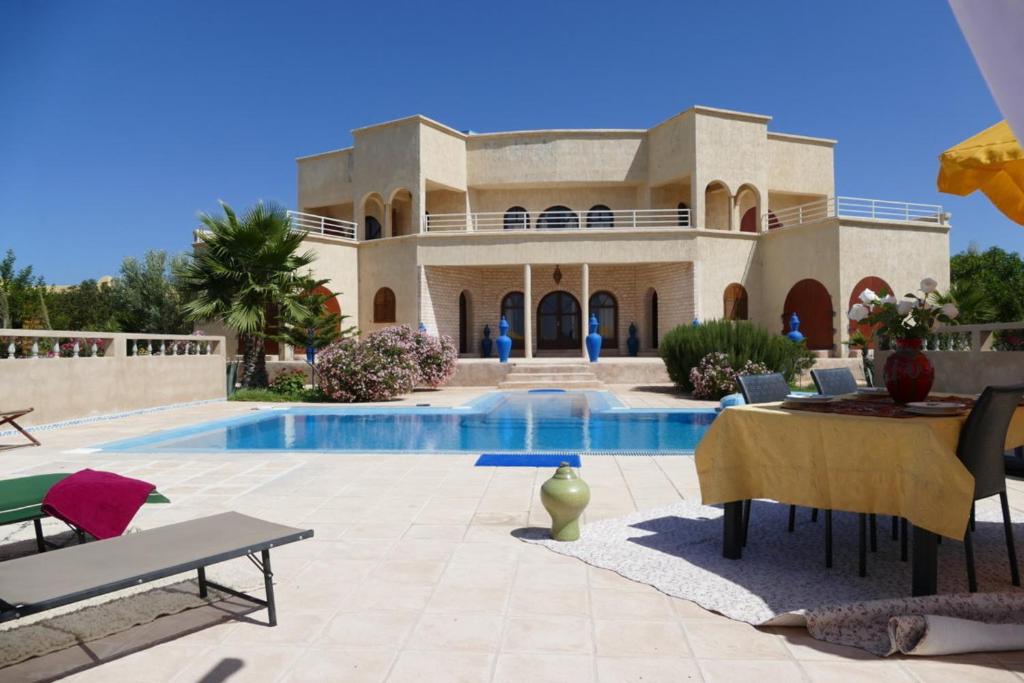 a villa with a swimming pool in front of it at Dar Yobedi in Essaouira