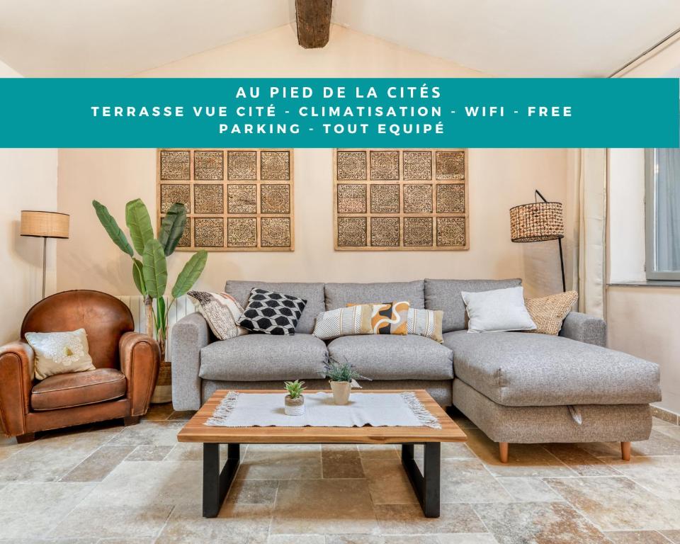 a living room with a couch and a table at Au Pied de la Cité - Terrasse - Climatisation - Wifi in Carcassonne