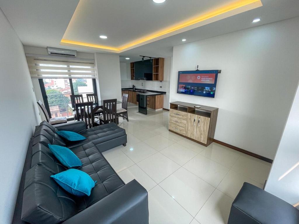 a living room with a couch and a flat screen tv at Two-bedroom apartment in Santa Cruz de la Sierra