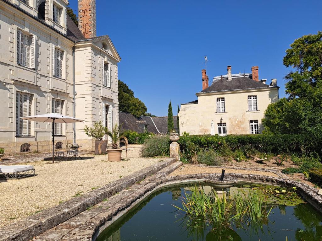 a garden with a pond in front of a building at Domaine de Planchoury in Saint-Michel-sur-Loire