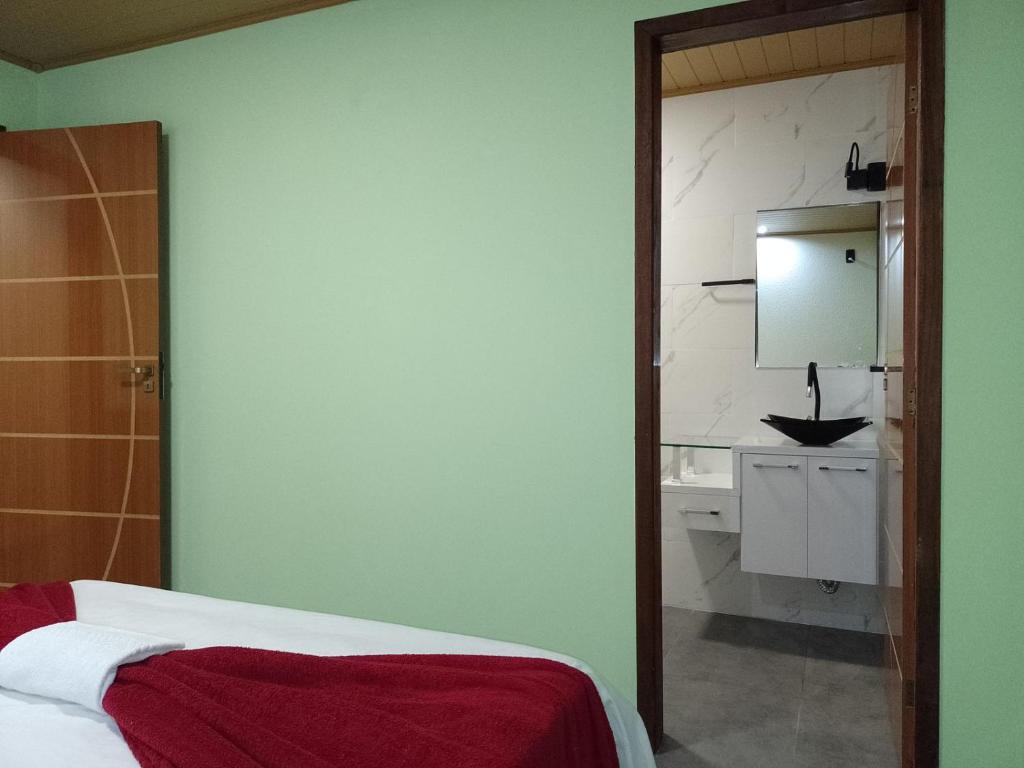 a bedroom with a bed and a sink and a mirror at Residencial Refugio do Mar in Florianópolis