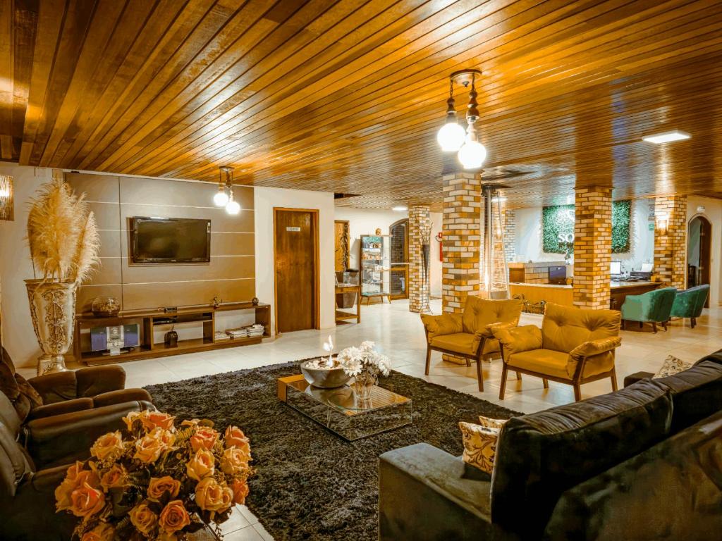 a large living room with couches and a tv at Hotel Sonnet Curitiba in Curitiba