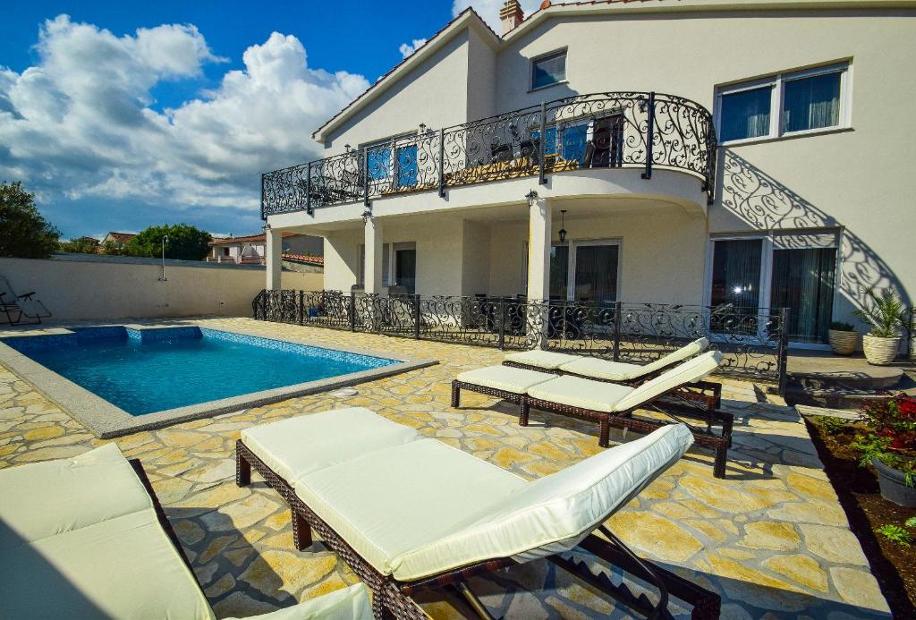 een villa met een zwembad en een huis bij Mary Rose in Vodice