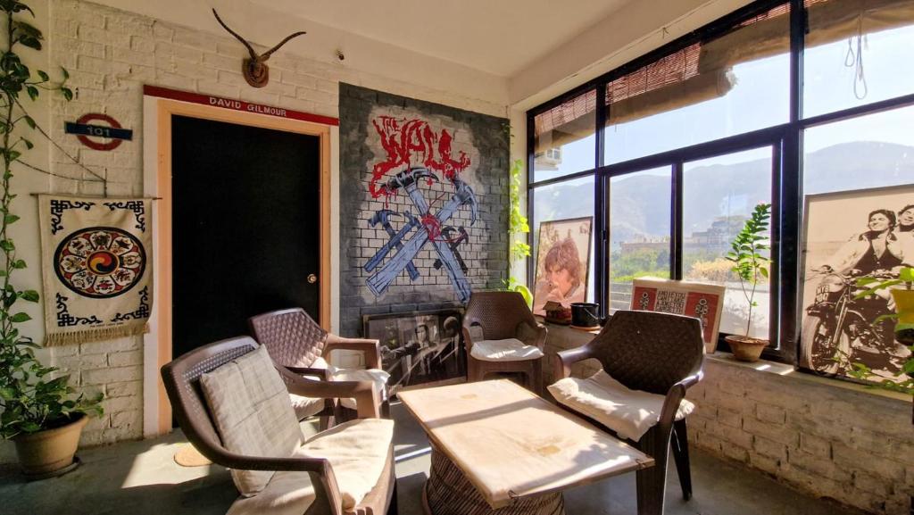 a room with chairs and a table and a window at Café The Wall in Pushkar