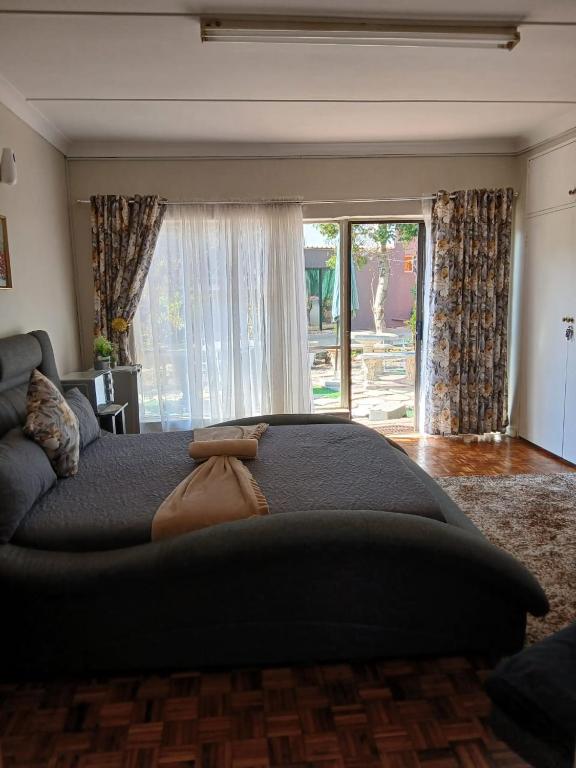 a bedroom with a large bed and a couch at Platinum Guesthouse in Klerksdorp